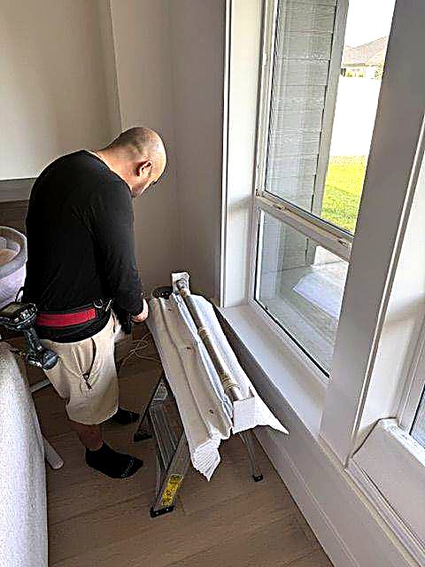 Technician preparing roman shades before installation